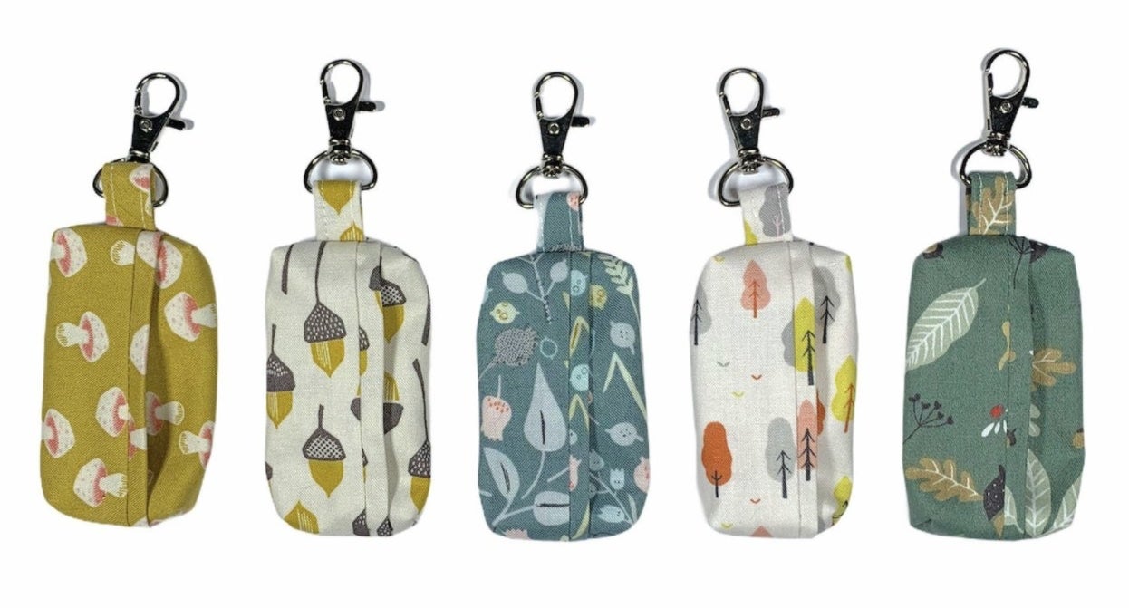 five pouches in different nature-inspired patterns like mushrooms and acorns