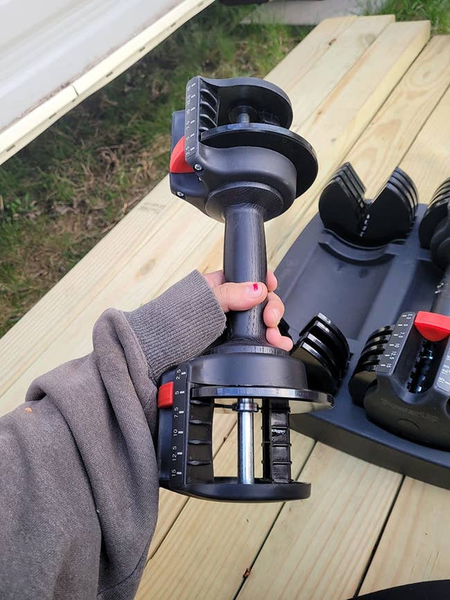pic of reviewer holding a black adjustable dumbbell in their hand