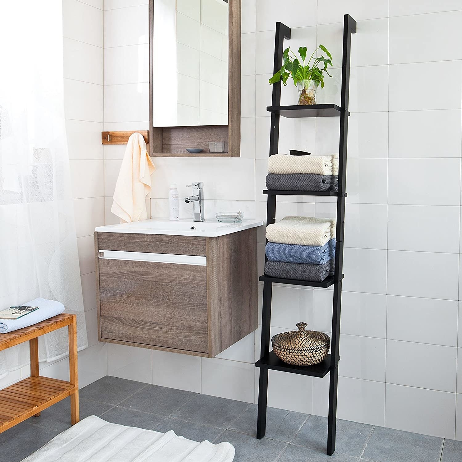 The ladder shelf in a bathroom with towels and decor on it
