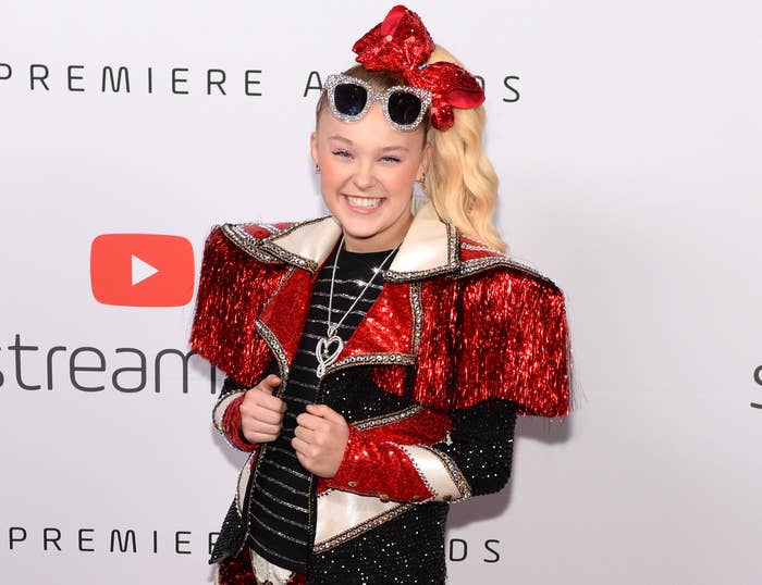 JoJo smiles in a sequined outfit on a red carpet