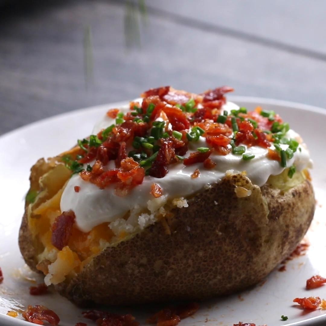 A baked potato stuffed with bacon, cheese, sour cream, and chives.