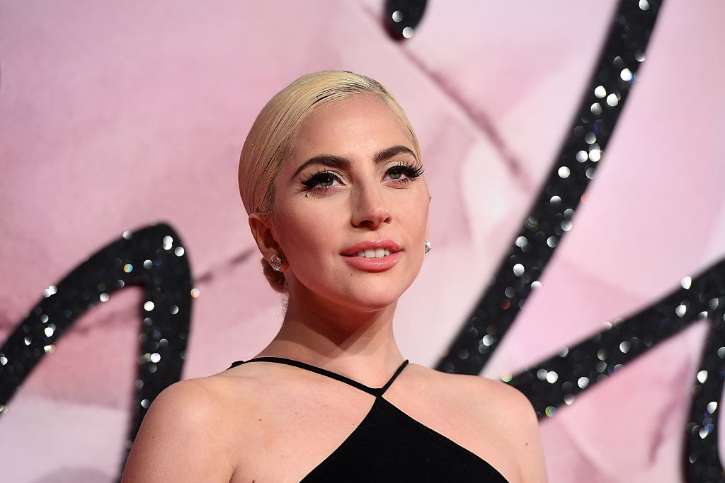 Lady Gaga with her hair pulled back and wearing a black thin-strap halter outfit