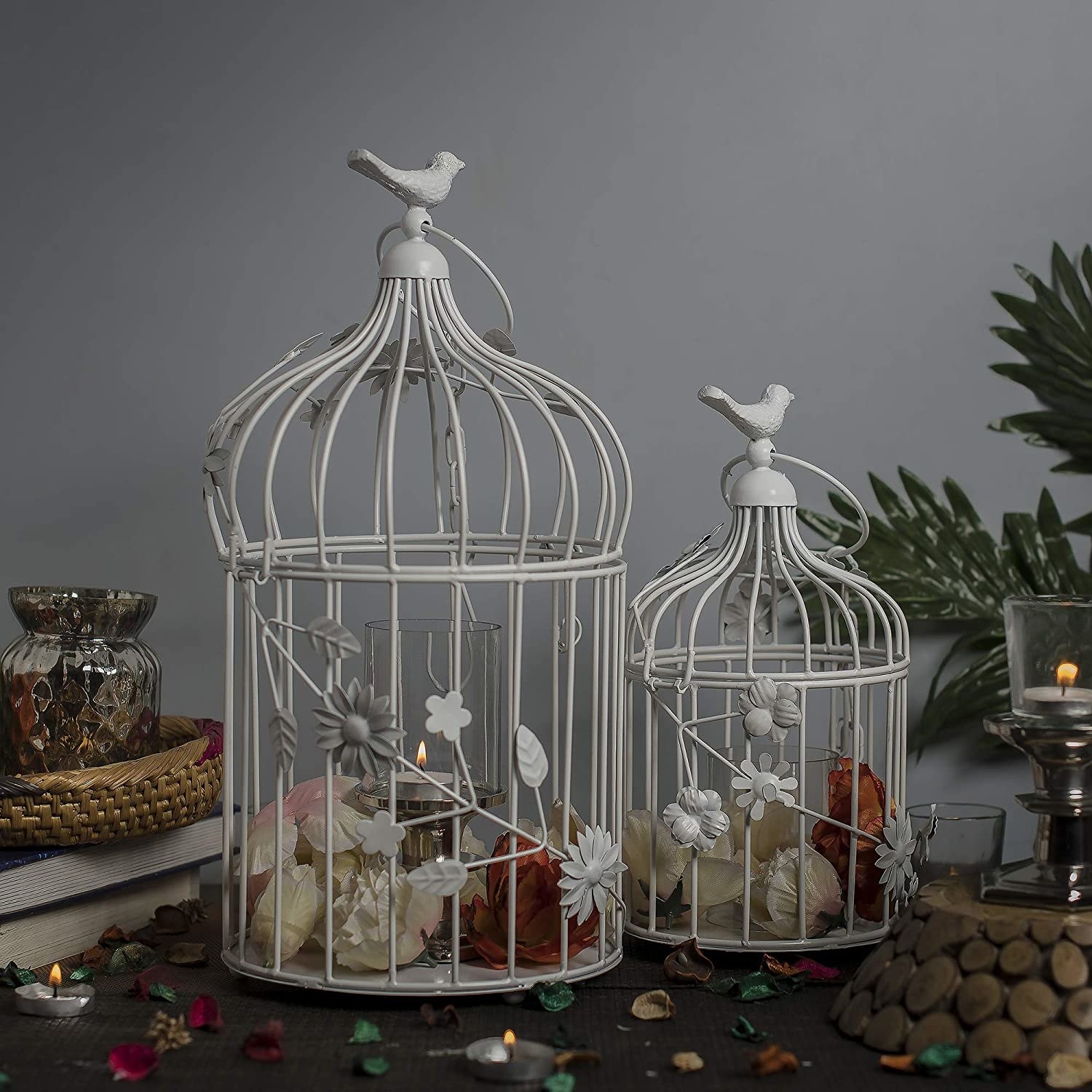 Birdcages with candles and flowers inside.