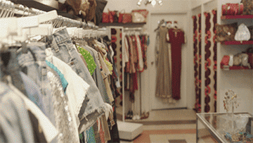 A man pulling clothing items from the rack