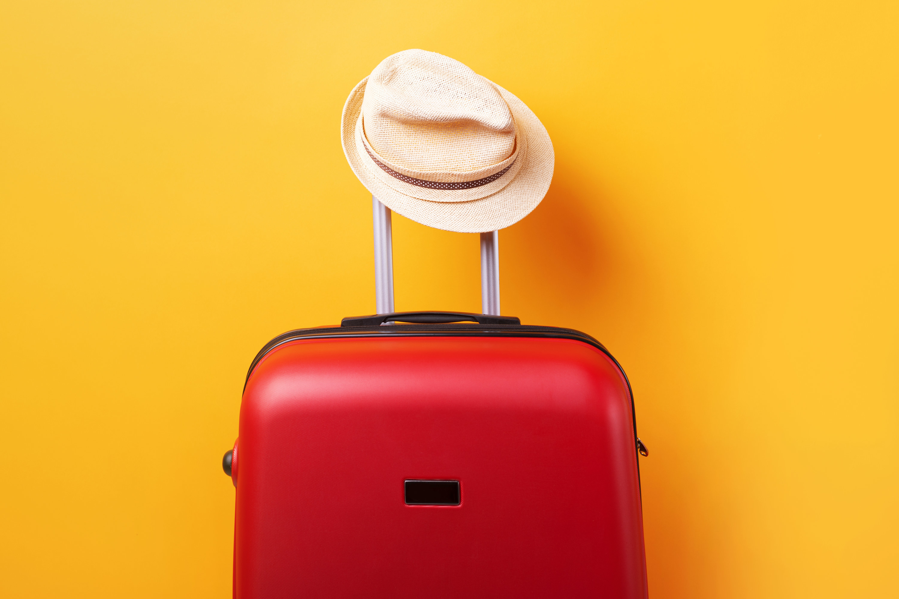 Suitcase with a hat perched on the handle