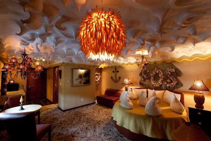 A coconut cream pie–themed hotel room with a ceiling that looks like meringue and a circular yellow bed