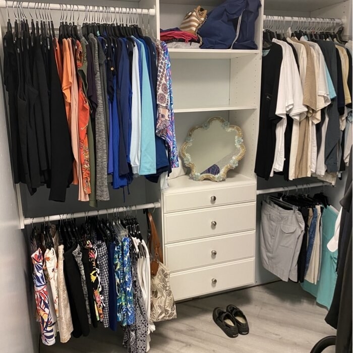 A reviewer photo of the closet system, which has a central drawer area, four hanging rods, and three shelves