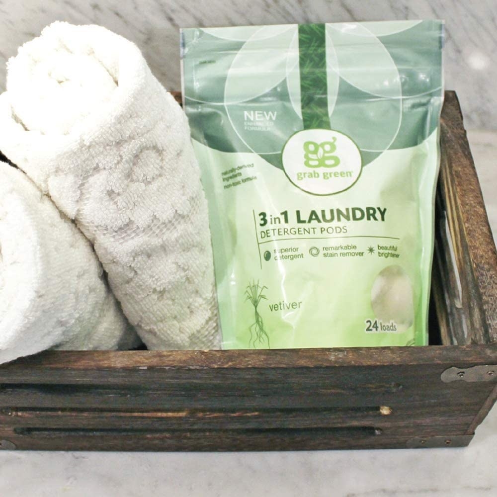 Bag of Grab Green laundry detergent pods placed in basket