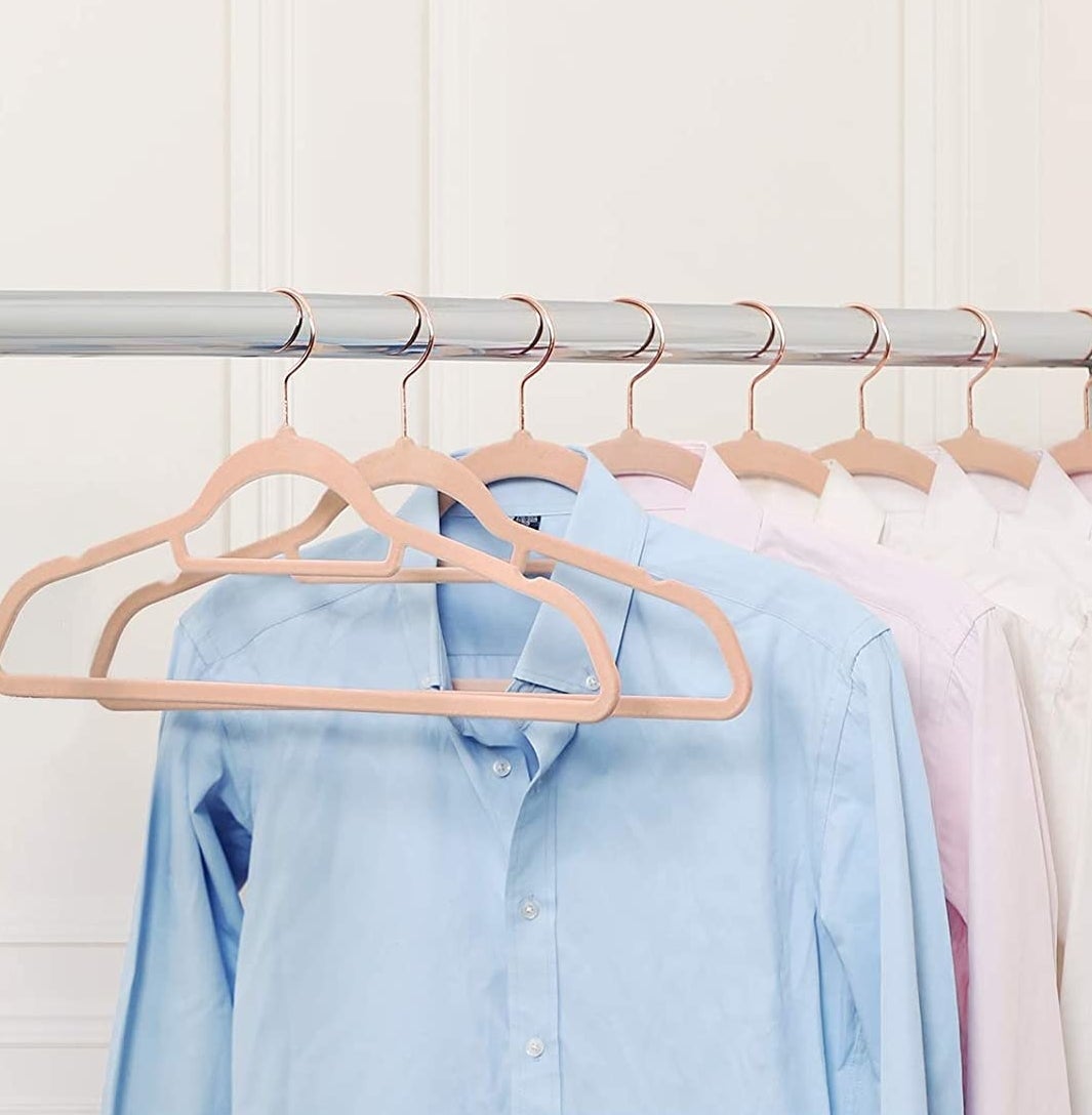 A set of velvet hangers on a clothes rack