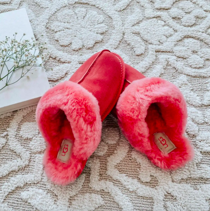 A pair of colourful shearling slippers on a shag carpet
