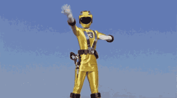 GIF of the yellow power ranger posing and fireworks appearing to come out of her backside