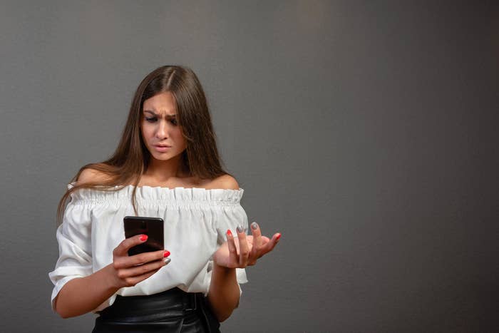 Confused girl looking at her phone