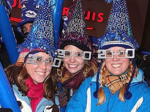 People celebrating New Year&#x27;s Eve by wearing glasses shaped like the numbers 2010