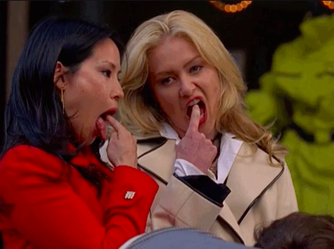 Lucy Liu and Portia de Rossi with their fingers in their mouths as if to say &quot;gag me&quot;