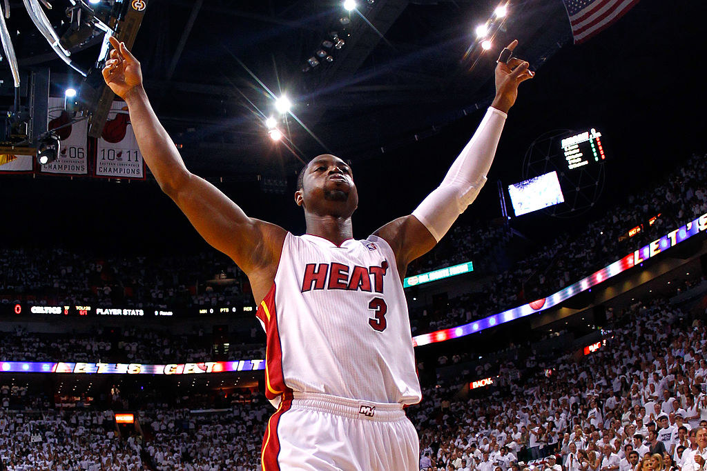 Dwyane raising his arms at a basketball game when he played for the Miami Heat