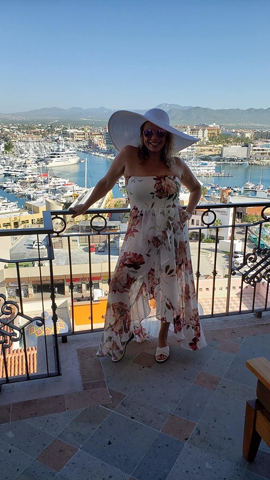 reviewer wearing the white derby wide brim sun hat on a terrace