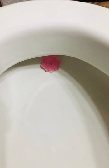 The Lysol automatic toilet bowl cleanser attached to toilet bowl