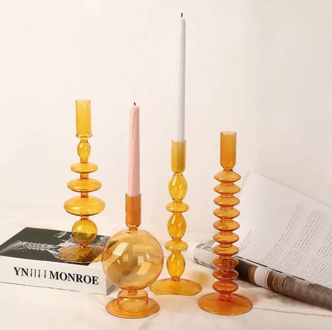 four orange candle holders of different styles