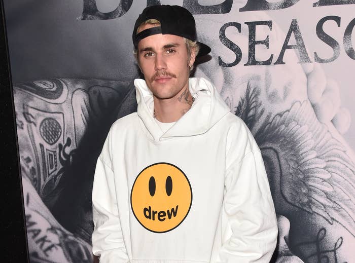 Justin wears a Drew sweatshirt while attending an event