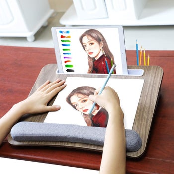 Model drawing a picture on the lap desk with a tablet propped in the slot at the top 
