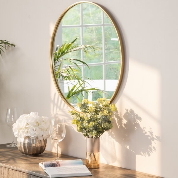 The mirror in gold, above a console table