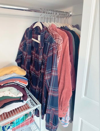 A BuzzFeed' editor's closet with shirts hanging on beige velvet hangers pressed together tightly 