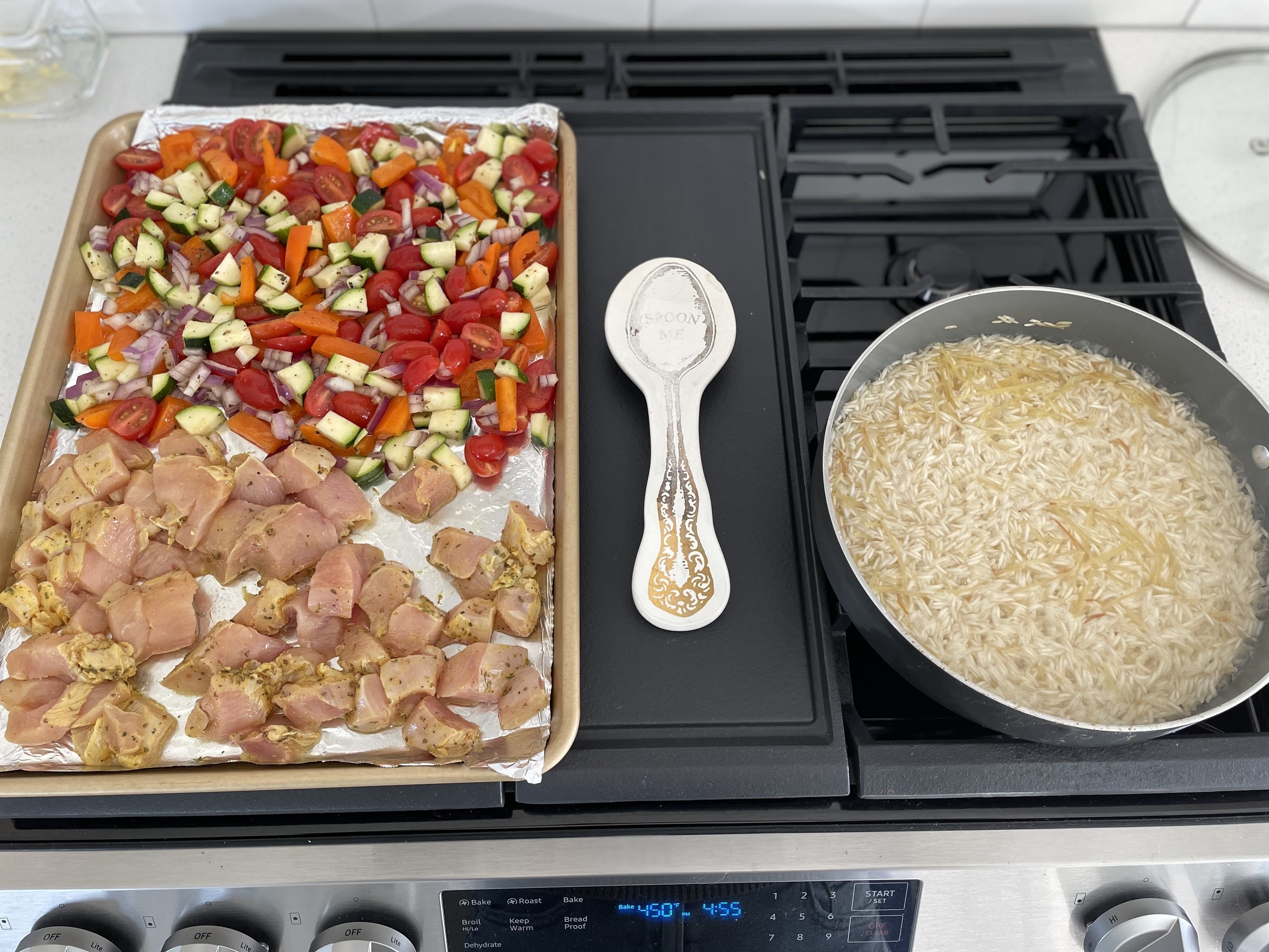 Green chicken bowl ingredients laid out on a sheet pan, ready to roast