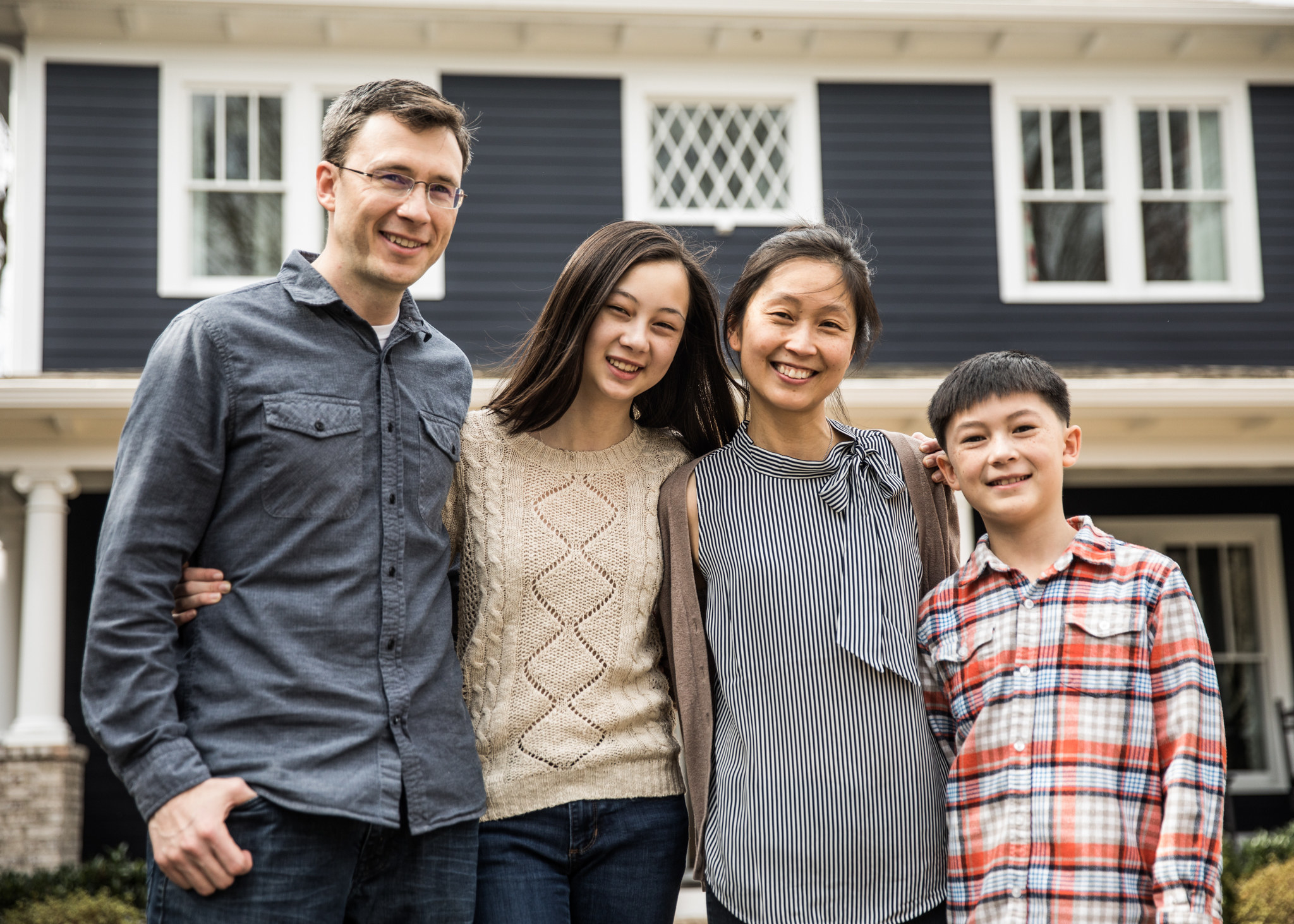 mixed race family smiling and posing together