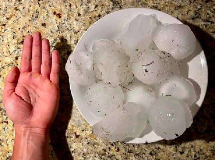 A hand next to a bowl filled with hailstones