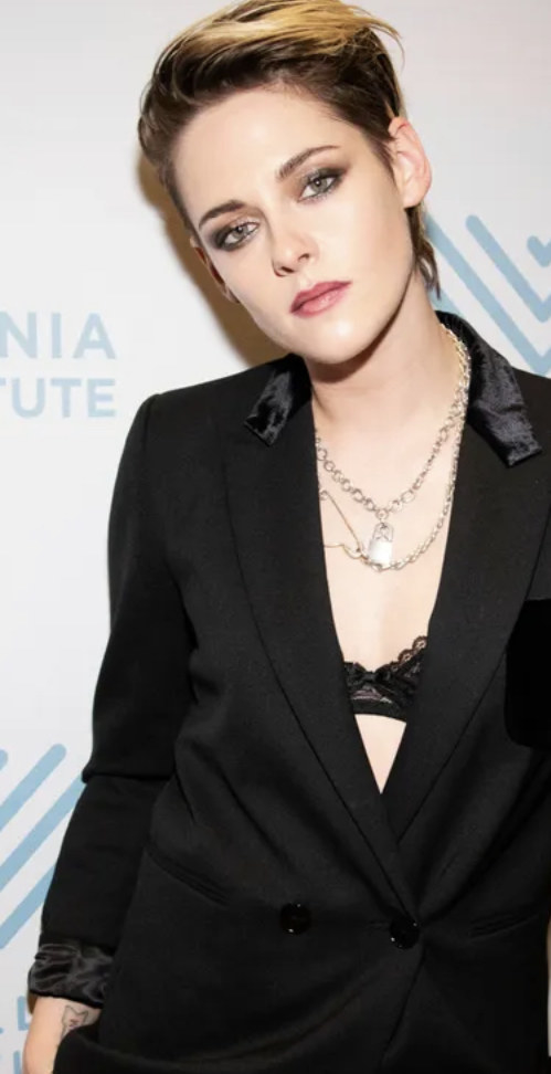 Kristen Stewart wearing a black suit without a shirt.