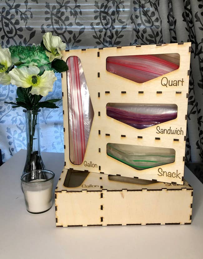 A wooden organizer with space for gallon, snack, sandwich, and quart-sized bags 