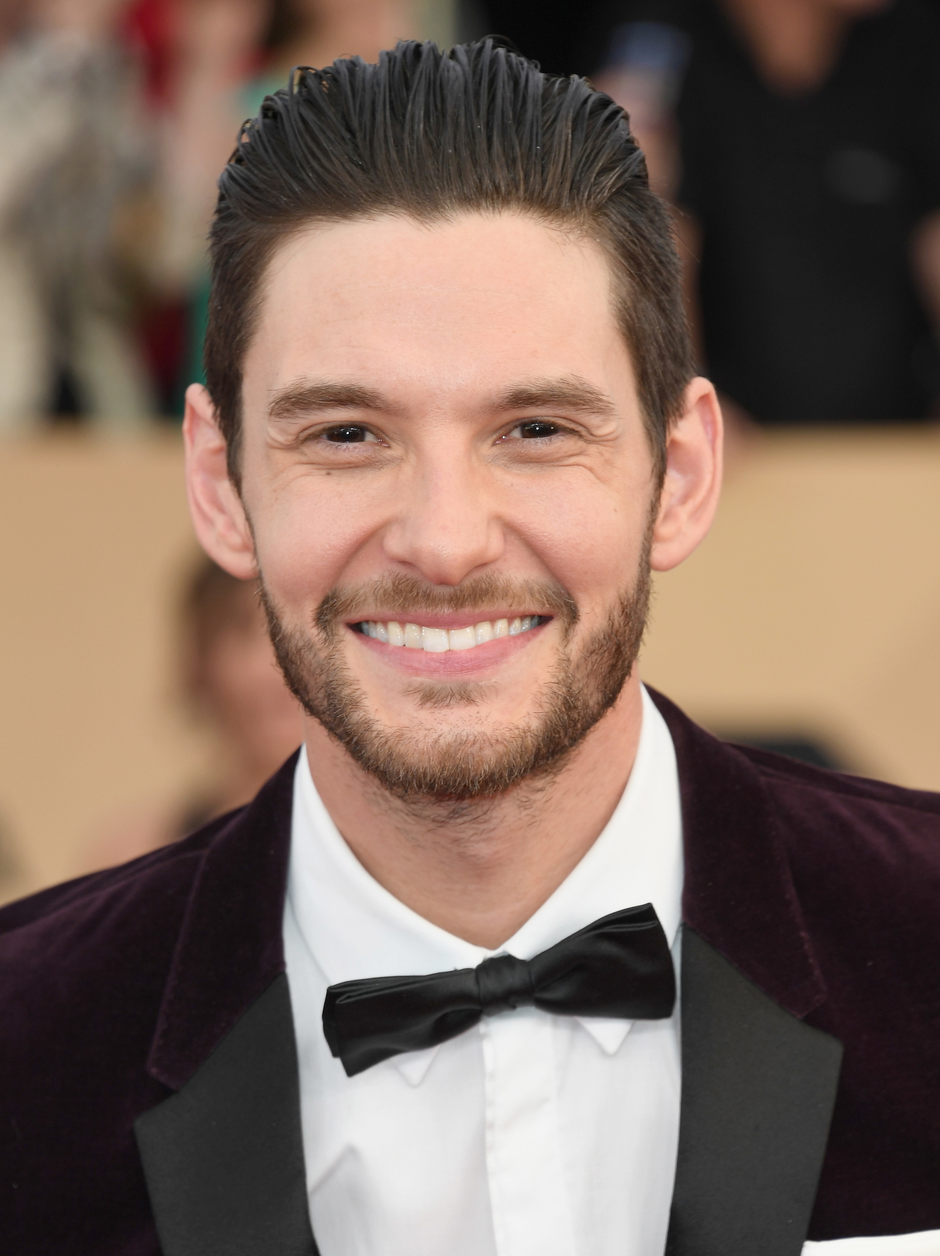 Ben Barnes in a suit, smiling at a red carpet event