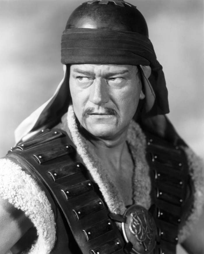 John Wayne is dressed up as Genghis Khan in a helmet and vest
