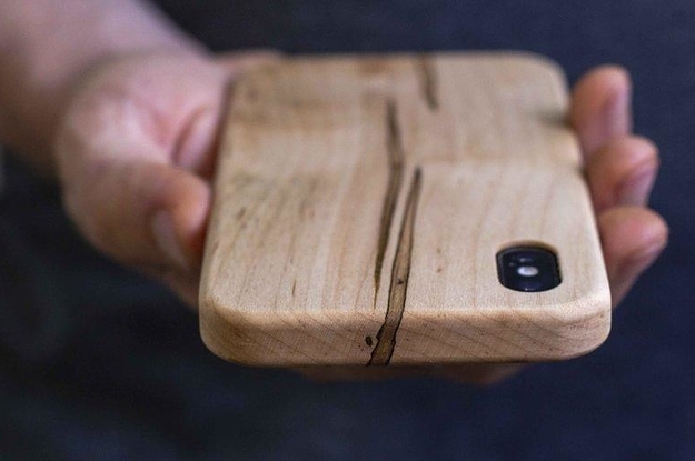 a model holding a light wood iphone case