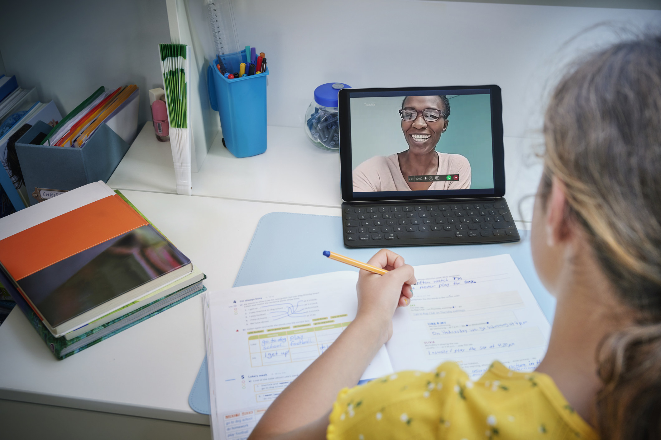 A student attending a virtual class on her tablet