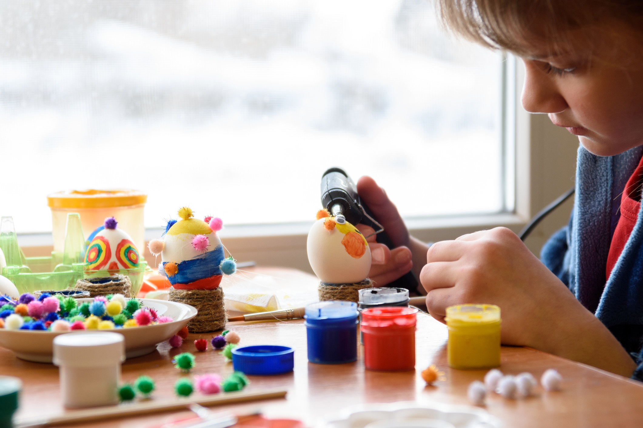 A child using a glue gun for an arts and crafts project