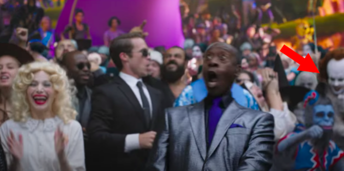 Pennywise in a crowd of people behind Don Cheadle