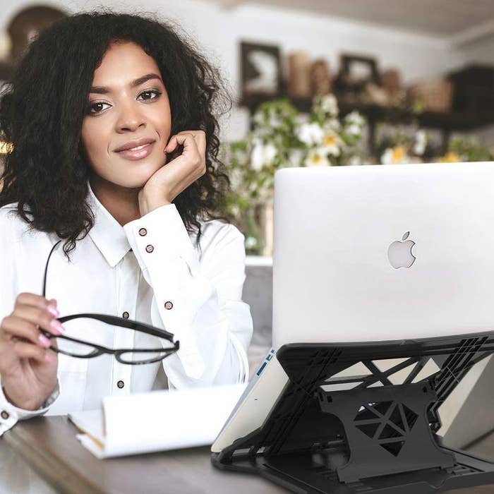 A woman with a laptop on the laptop stand 