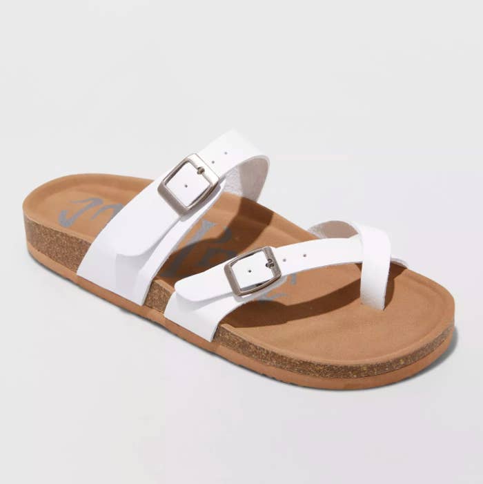 the tan and white sandals with buckles and a toe strap