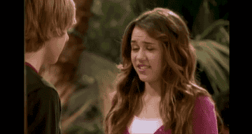 Miley awkwardly bites her lip while talking to Jake