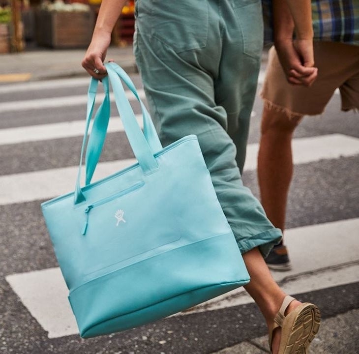 A person walking across a street carrying the bag