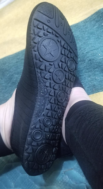 Reviewer showing grippers on the bottom of the shoe 