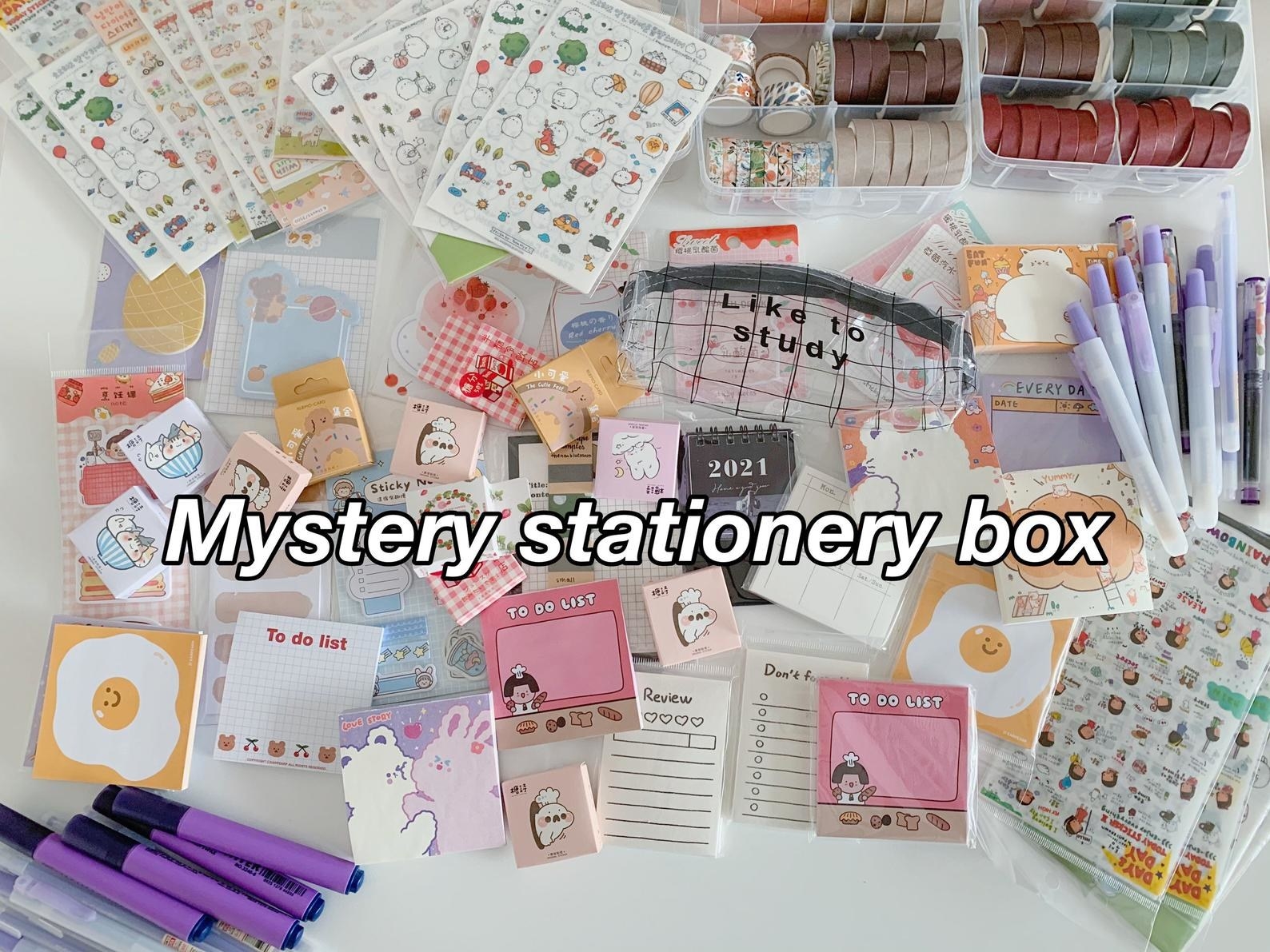 a pile of stationery items with the text mystery stationery box across it