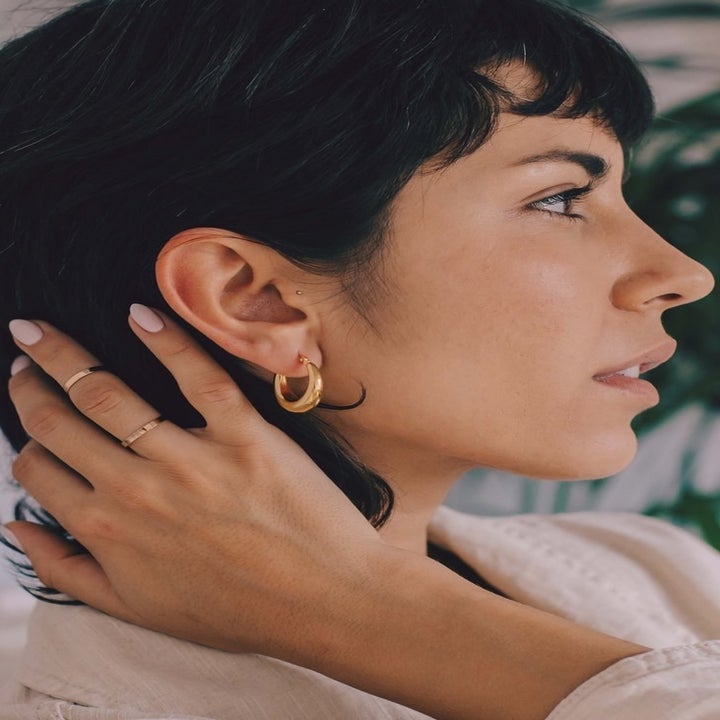 side view of a model wearing the gold hoops