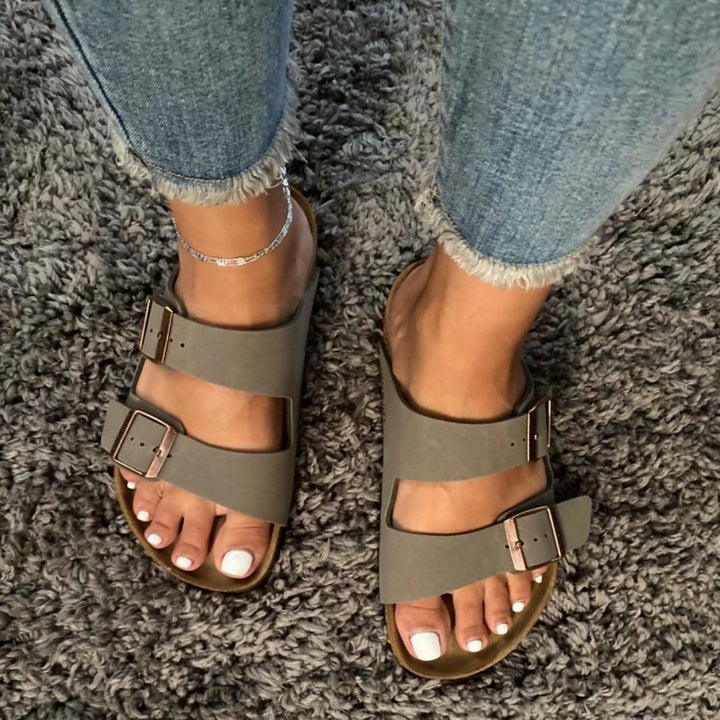 a reviewer wearing the sandals in stone