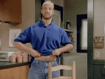 Chris Elliott indicating his belly button