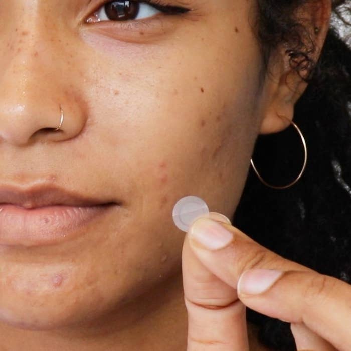 A close up of a person holding one of the pimple patches