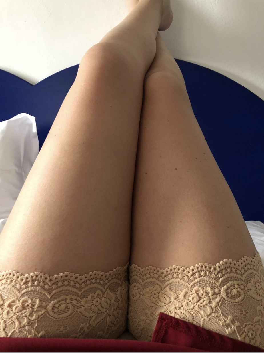 Reviewer in beige colored lace thigh bands under a dress 