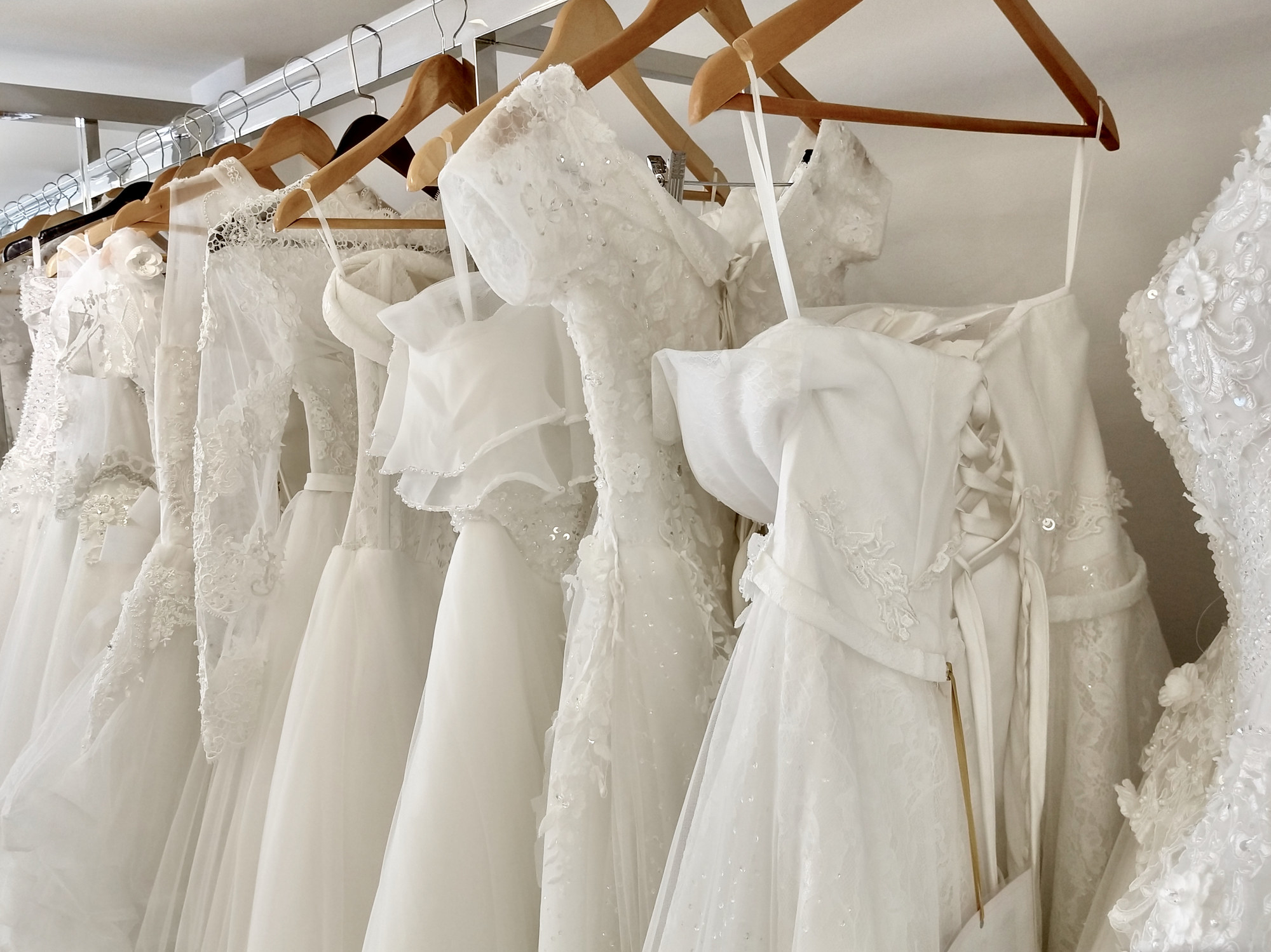 A shopping rack of white wedding dresses