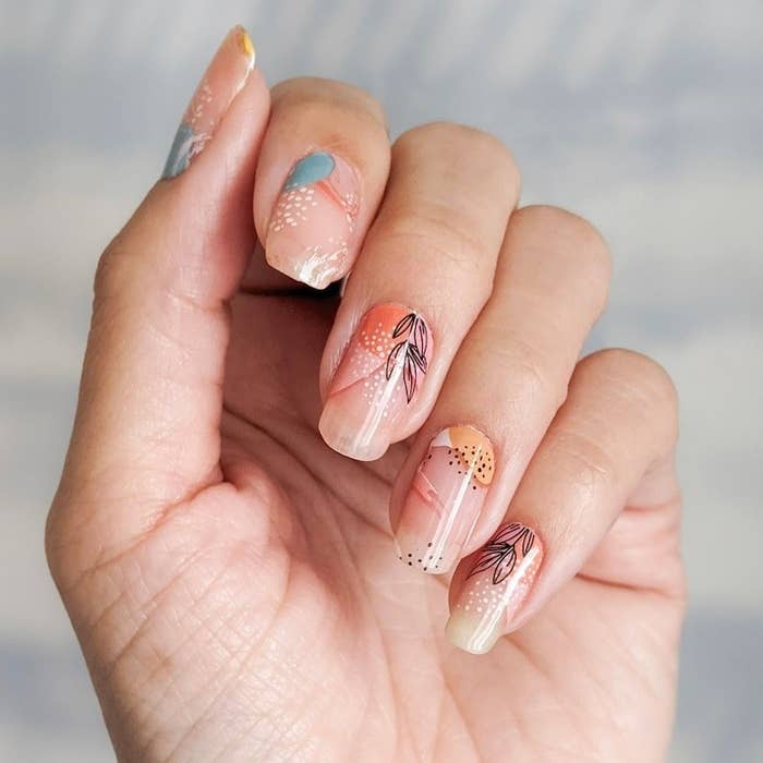 model&#x27;s hands with floral nail wraps